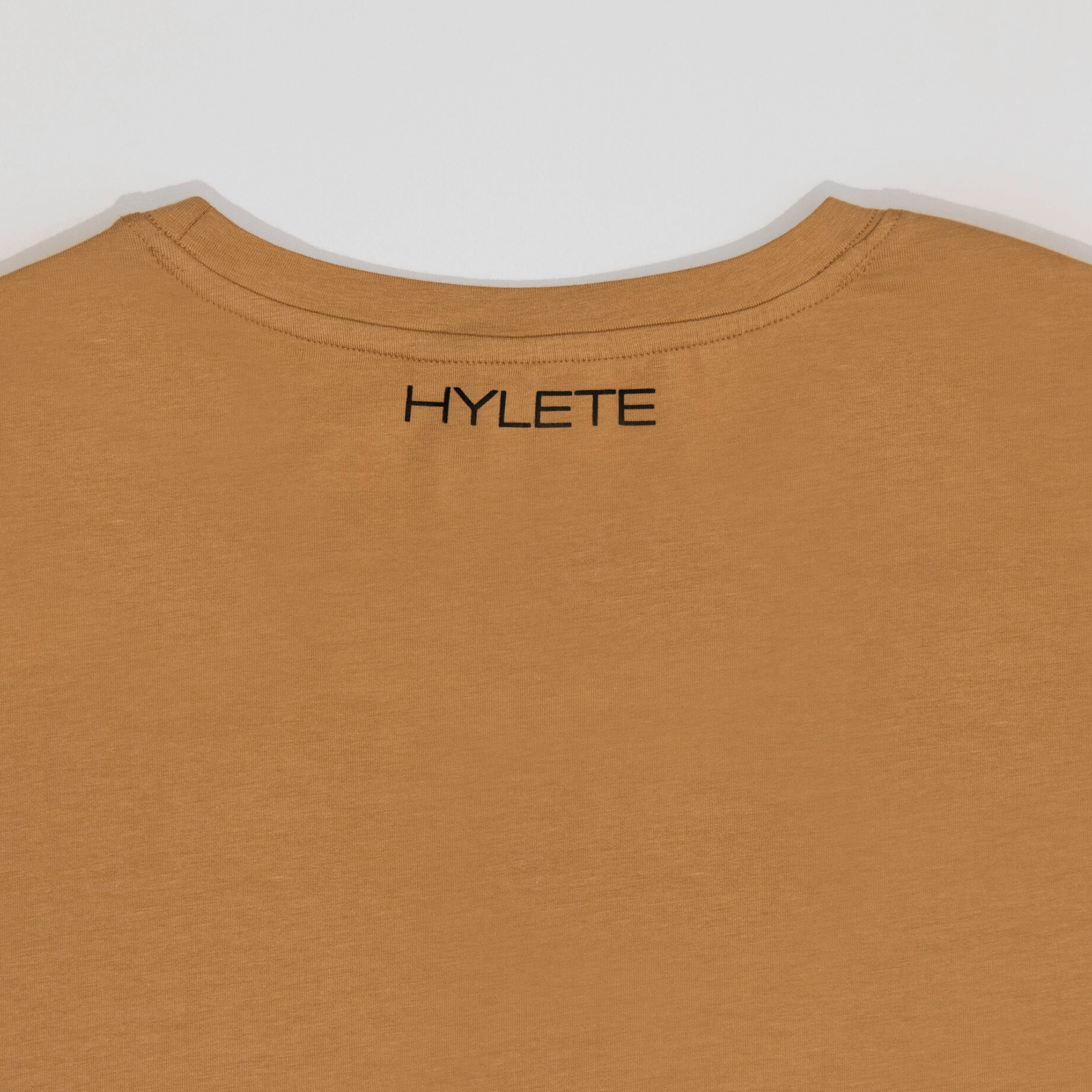 Tan HY-Blend Crew Tee with Hylete logo on back neckline, showcasing a minimalist design and high-stretch fabric for versatile athletes.