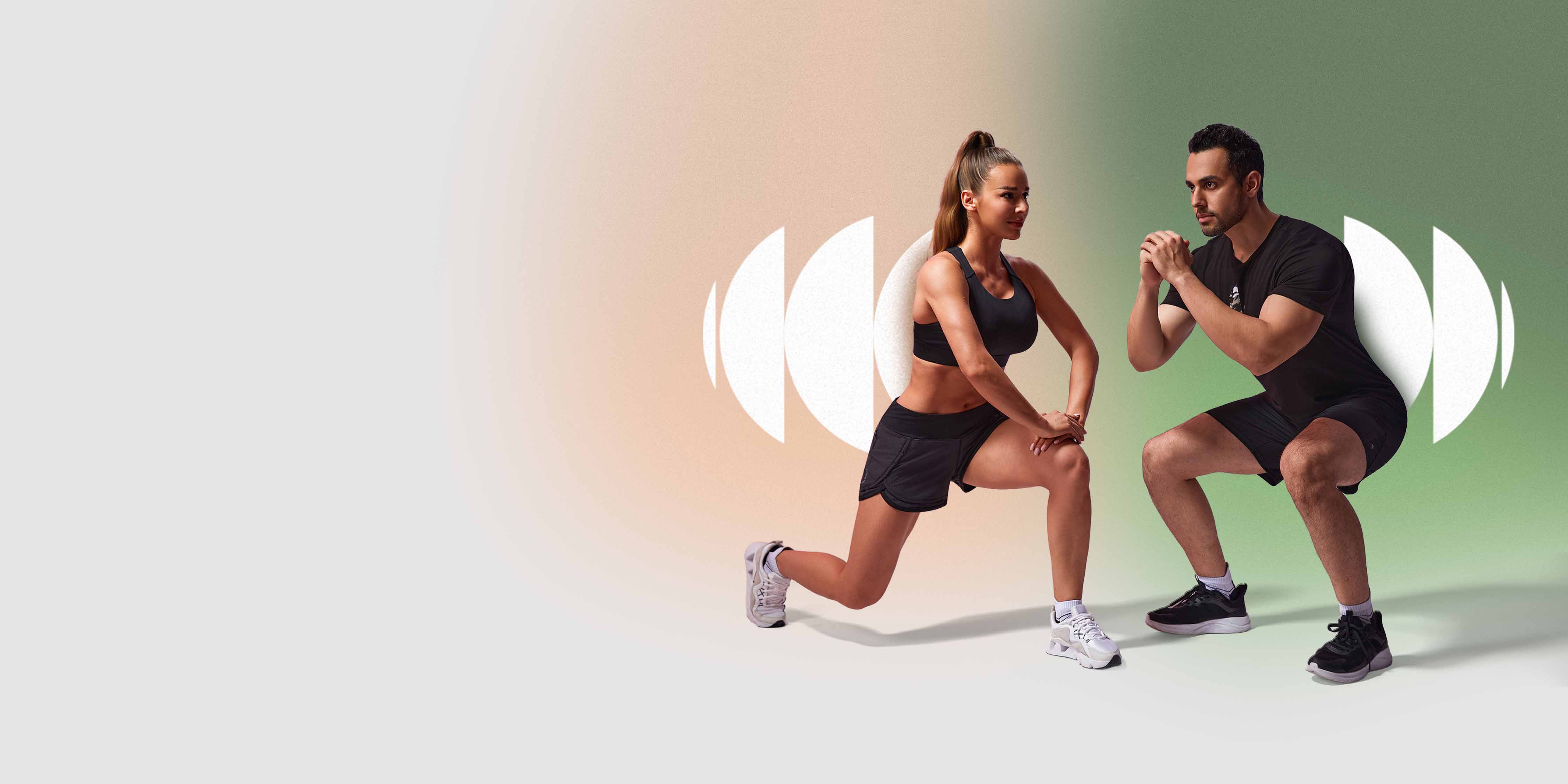 A man and woman, both wearing Hylete athletic gear, perform a lunge and a squat side-by-side.