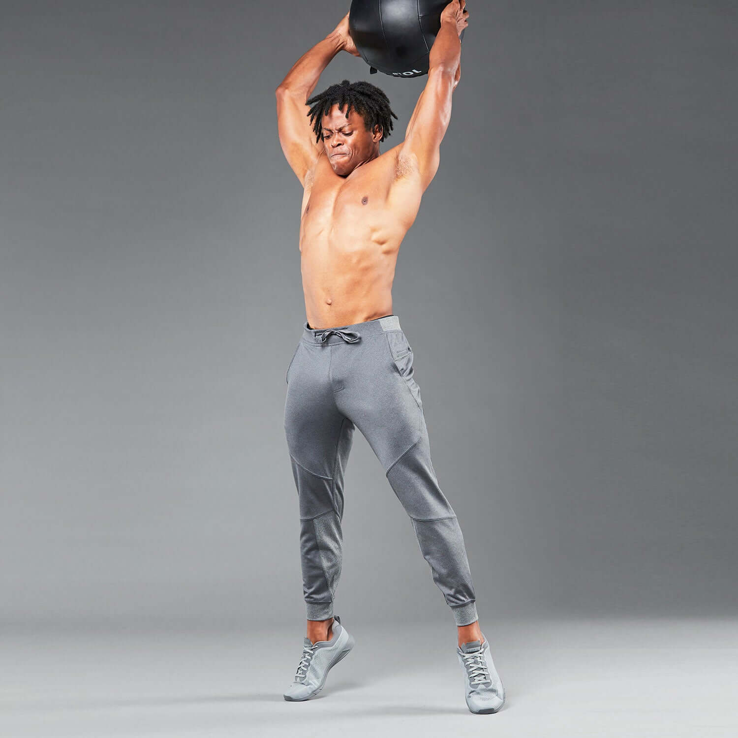 Man in Flexion II Jogger Heather Slate/Gray performing an overhead exercise for optimal comfort and flexibility.