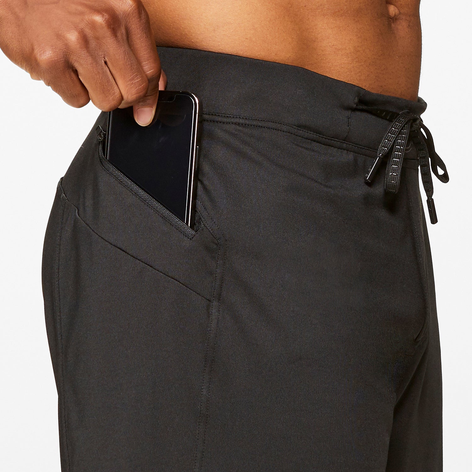 Helix III Short Black with phone in pocket, showcasing practicality and style for active workouts.