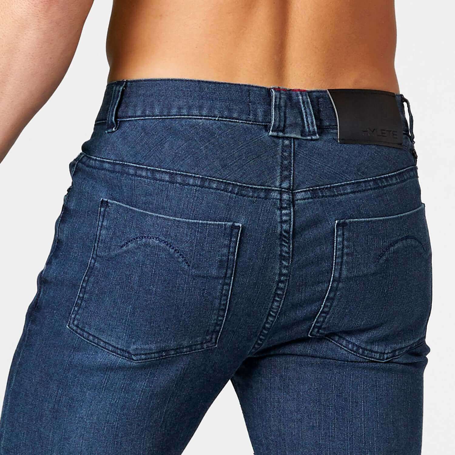 Back view of Optic II Denim Indigo Stealth Black jeans showcasing 4-way stretch fabric and roomy cut for comfort and style.