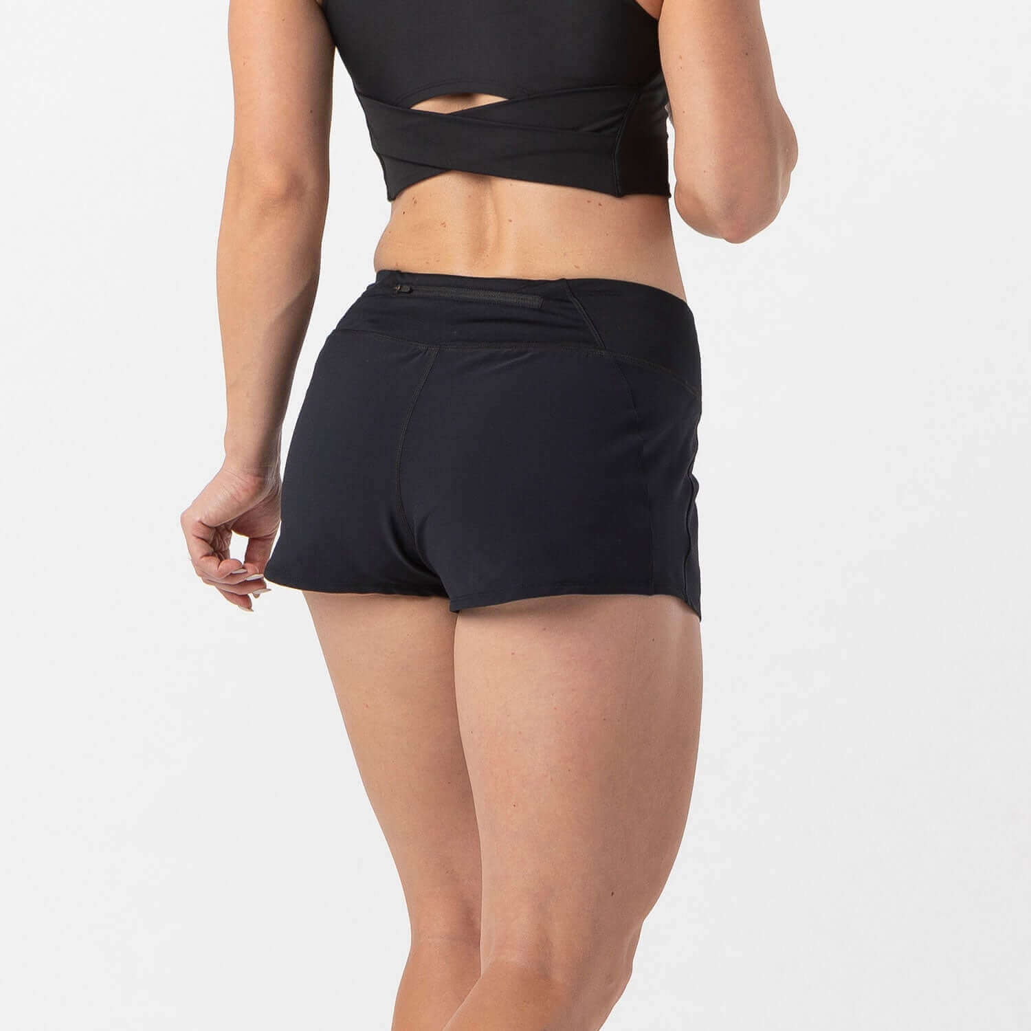Woman wearing Vita Short Black, designed for runners and HIIT athletes with a smooth-stretch waistband and zippered pocket.