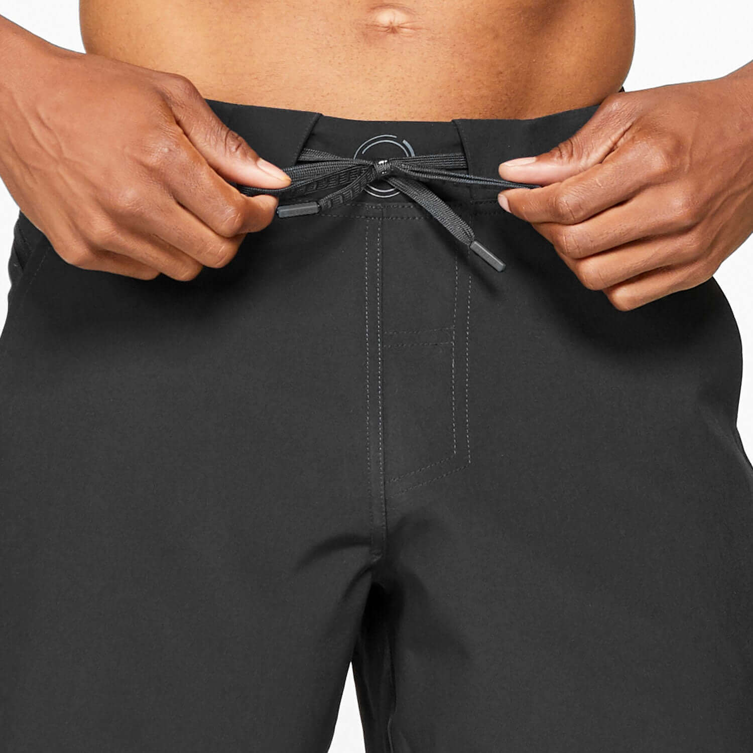 Close-up of hands tying drawstring on Verge III Short Black, showcasing its lightweight and quick-drying fabric.