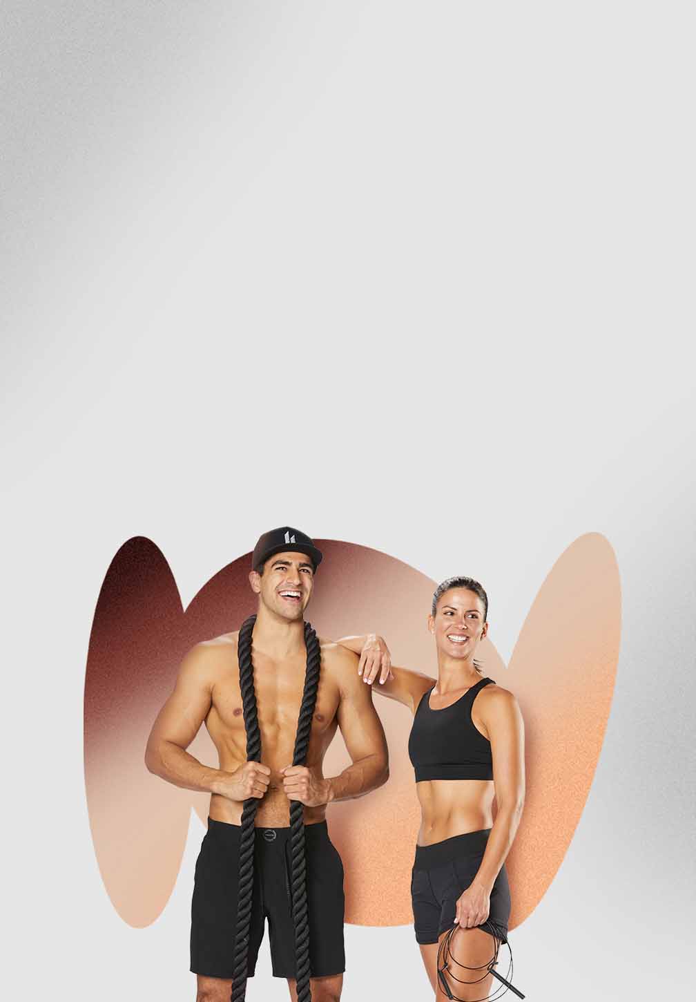 A shirtless man with a black hat and shorts holds a large battle rope over his shoulders, smiling at the camera. A woman in a black sports bra and shorts leans her head on his shoulder, holding a jump rope. Both are in athletic Hylete gear and appear to be fit and happy.