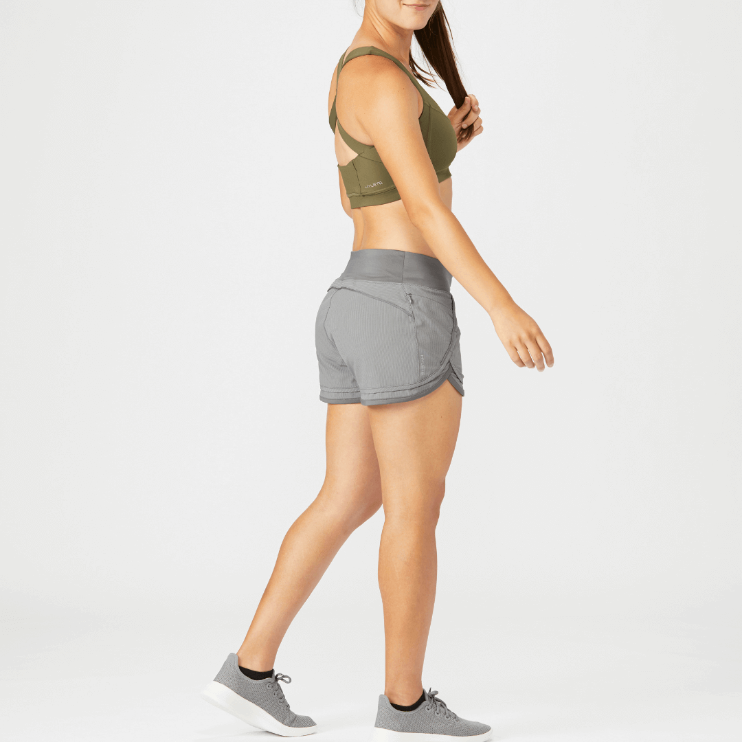 Woman wearing Iris Lined Short in cool gray, showcasing flexible fit and breathable design for workouts.